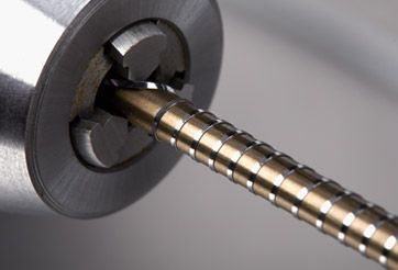 Close-up of a metal braided cable passing through a dark circular fitting