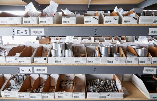 Shelved bins of assorted hardware parts and fasteners in a workshop storage area