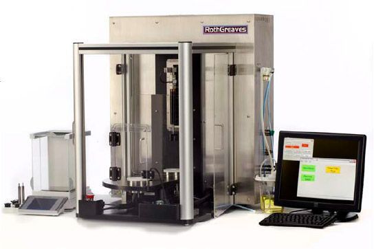 Industrial testing machine with enclosed frame and attached monitor on a white background