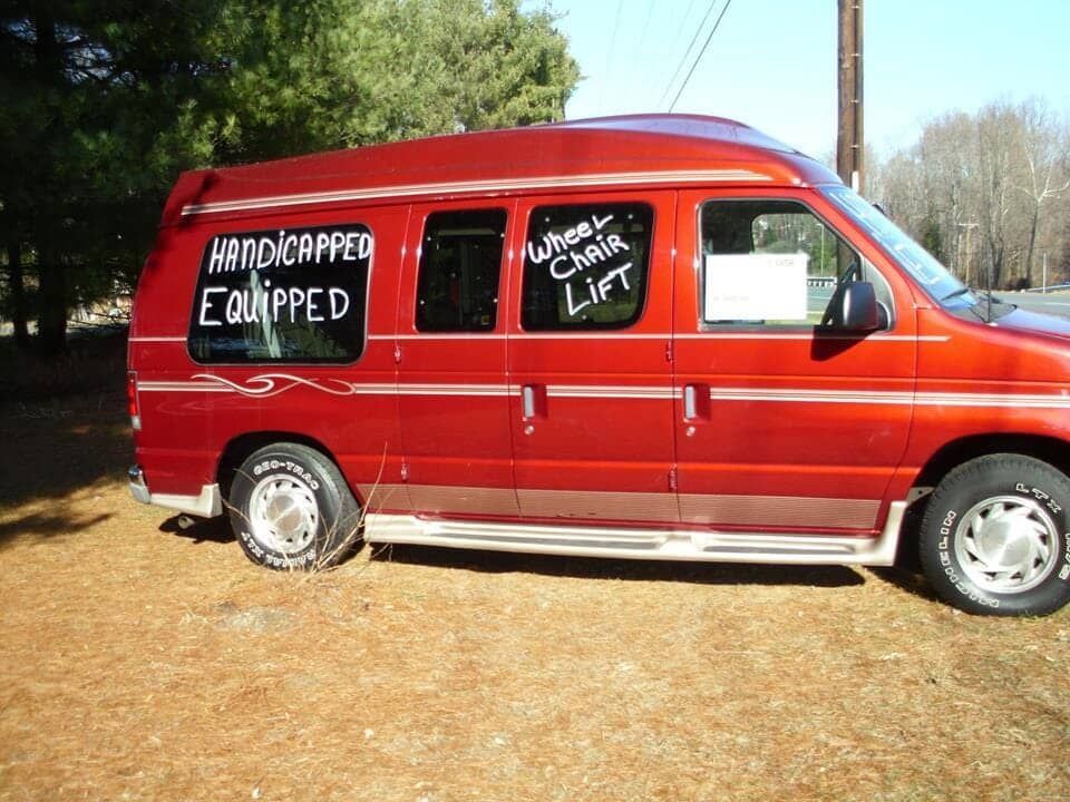A red van with the words handicapped equipped on the side