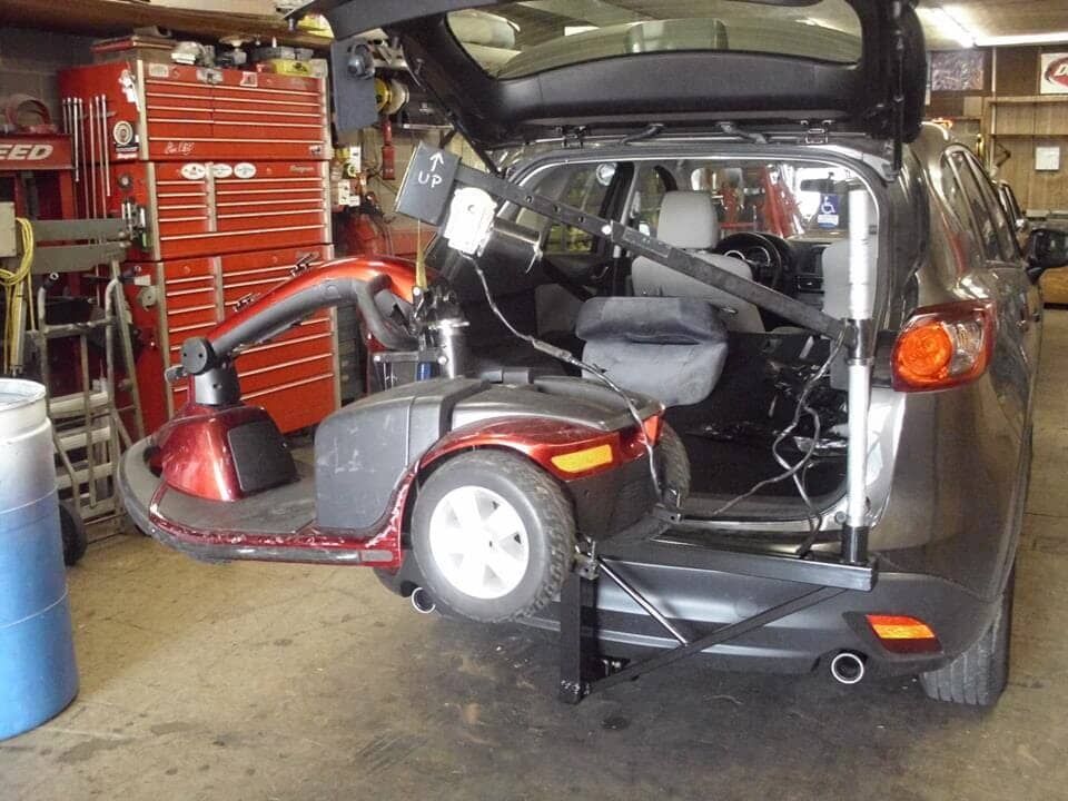 A mobility scooter is attached to the back of a car
