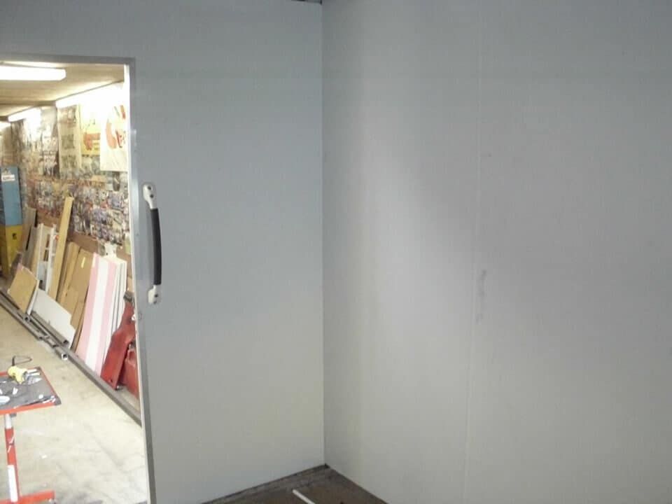 A room with a door that is open and a wall that is empty.