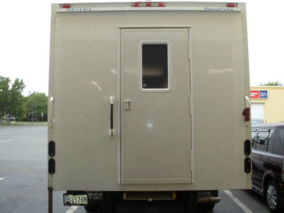 A truck with a door and a window is parked in a parking lot.