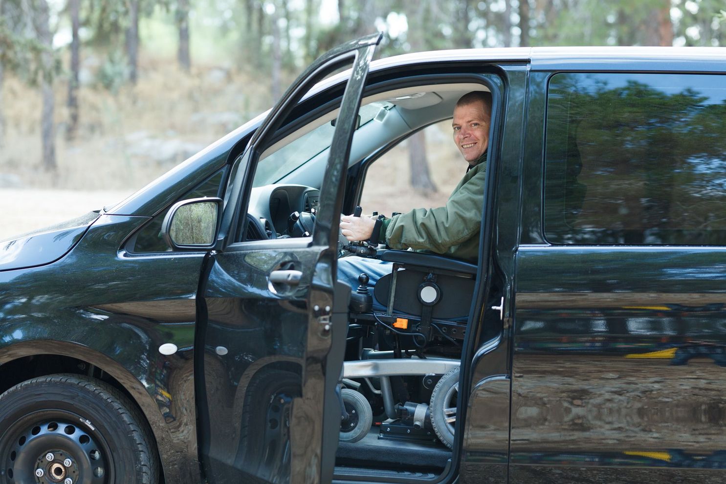A Man in a Wheelchair is Sitting in a Van With the Door Open