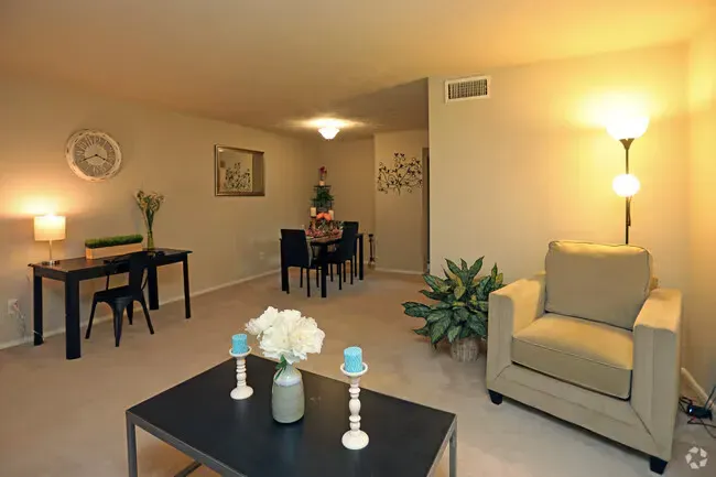 Living room with black furniture, dining table, armchair, and floor lamp; neutral color palette.