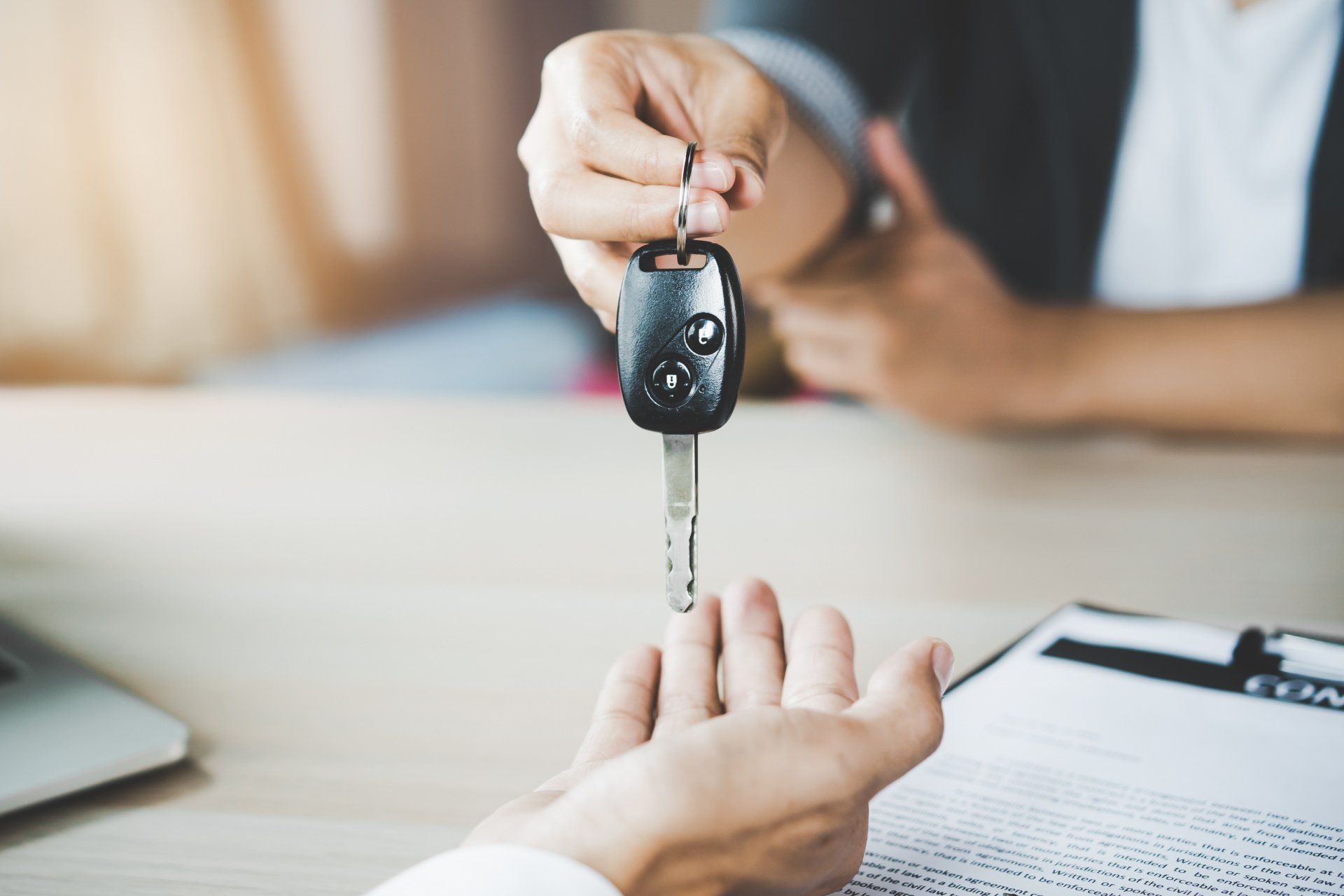Person handing keys to new vehicle owner