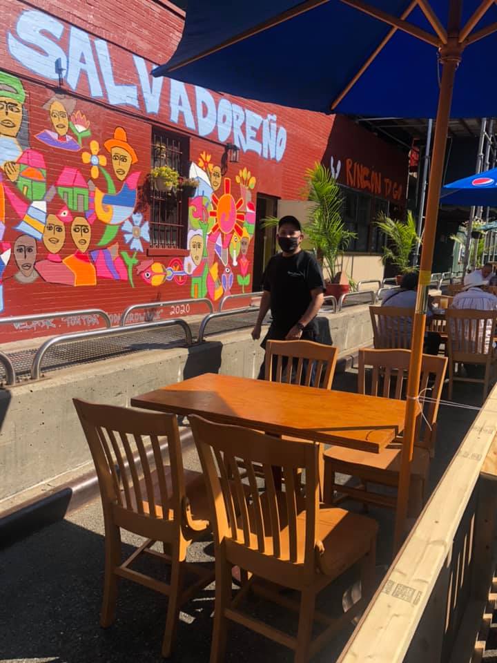 A man is standing in front of a salvadoreno restaurant