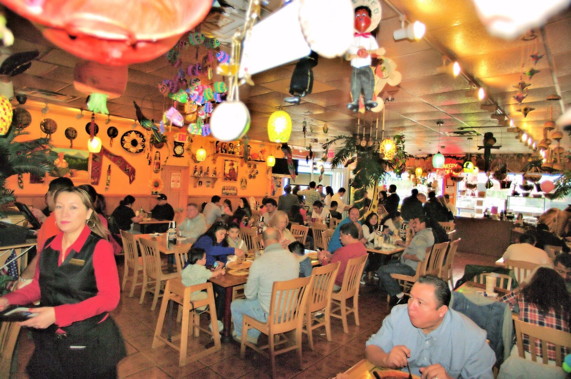 A restaurant with a lot of people sitting at tables