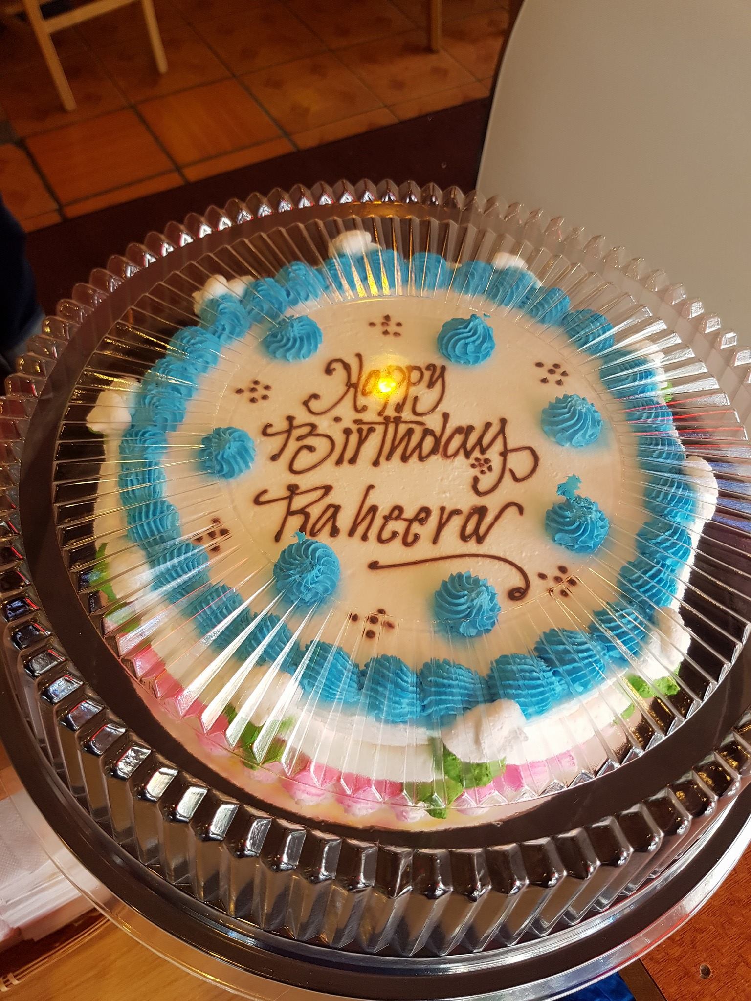 A birthday cake in a plastic container that says happy birthday bakeera