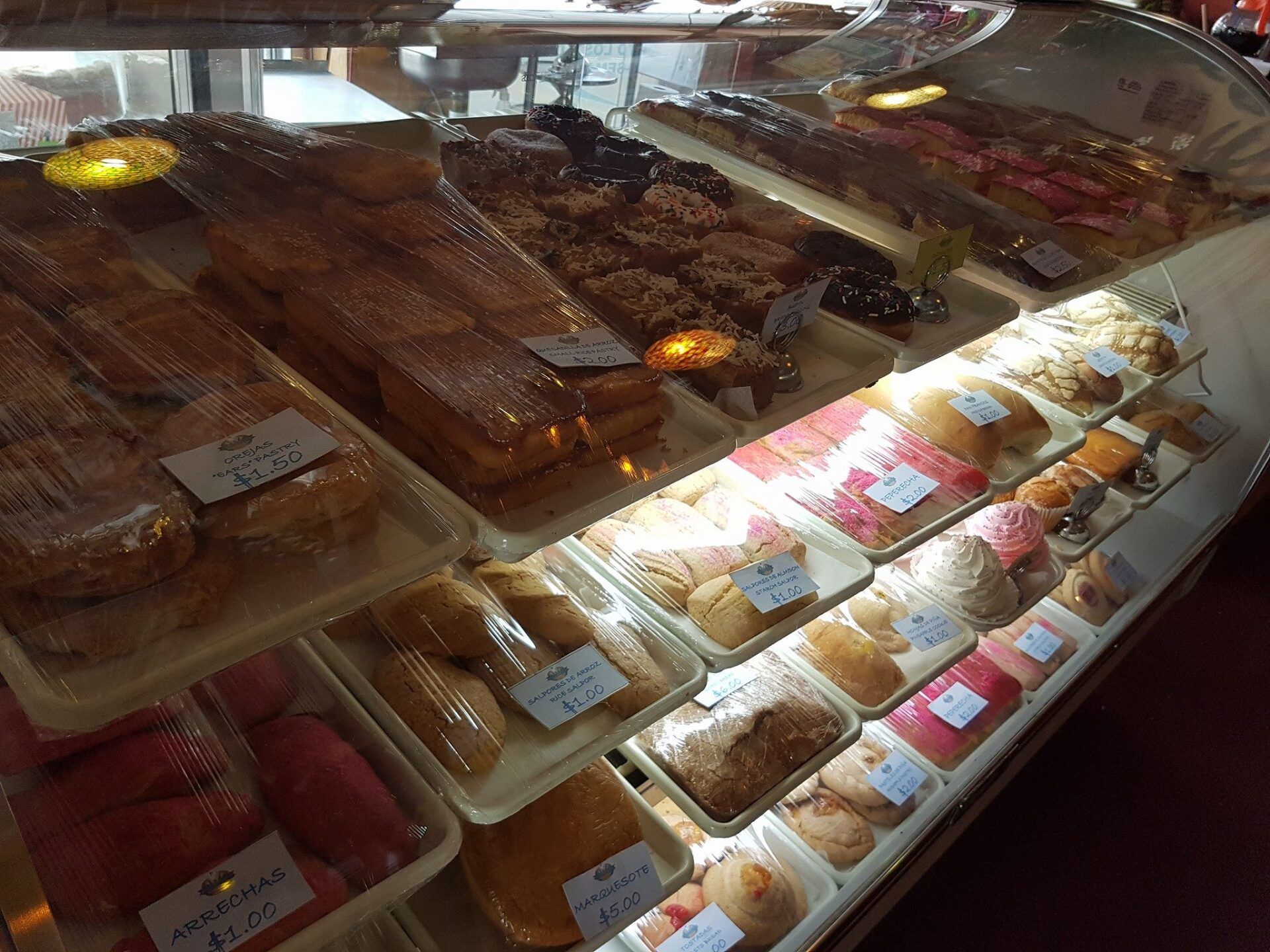 A display case filled with a variety of pastries and breads