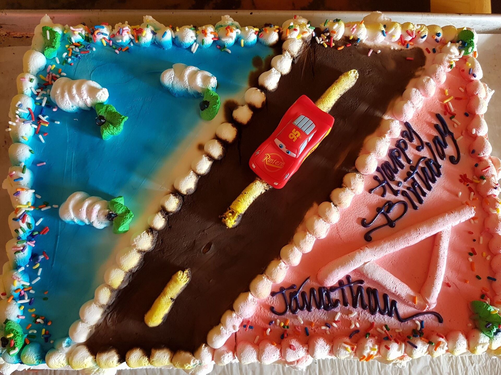 A birthday cake for jonathana with a car on it