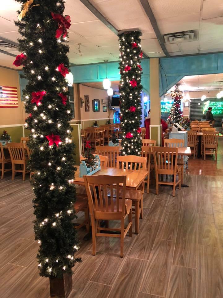 A restaurant with tables and chairs decorated for christmas