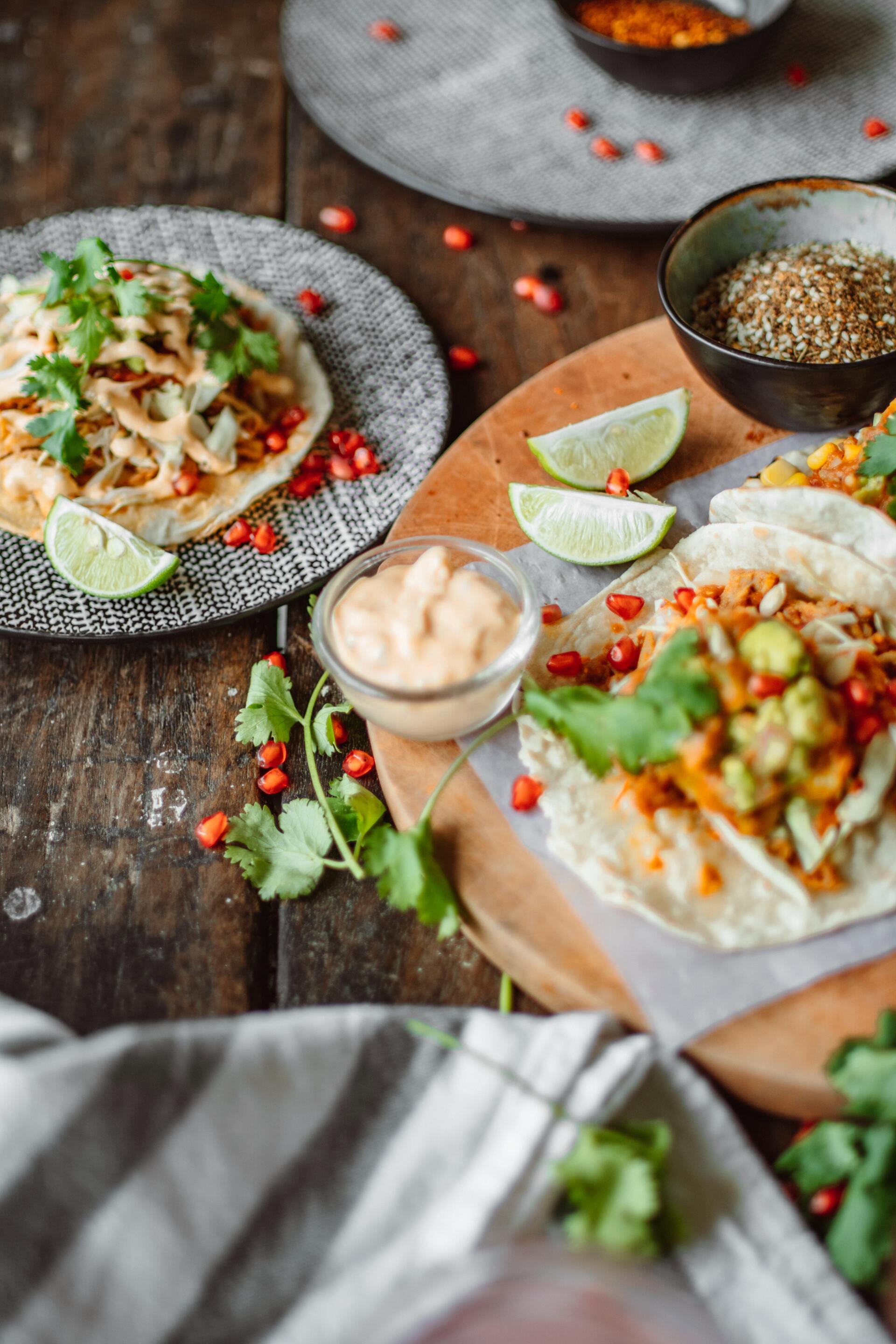 A wooden table topped with plates of food and sauces.