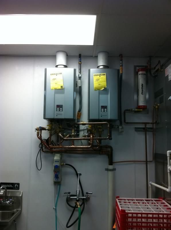 A kitchen with two water heaters and a sink