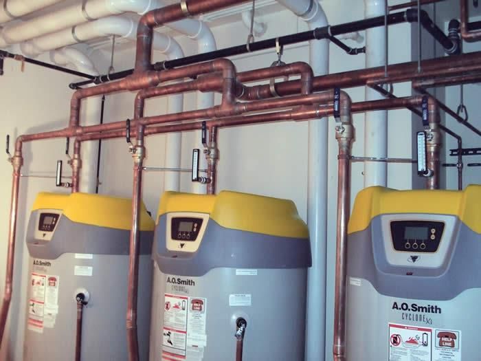Three a.g. smith water heaters are lined up in a room