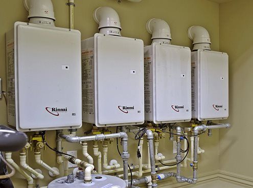 A row of water heaters are lined up next to each other in a room.