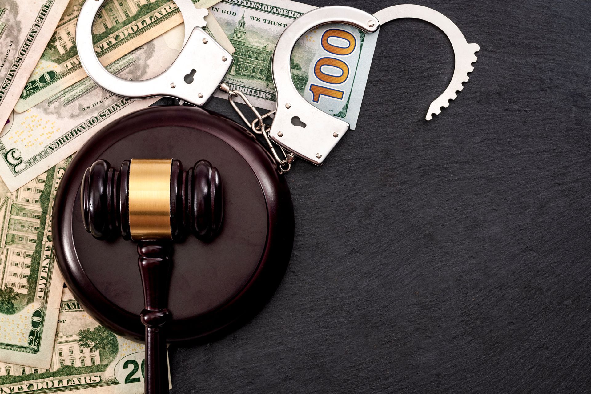 A gavel, handcuffs and money, representing the bail bonds process