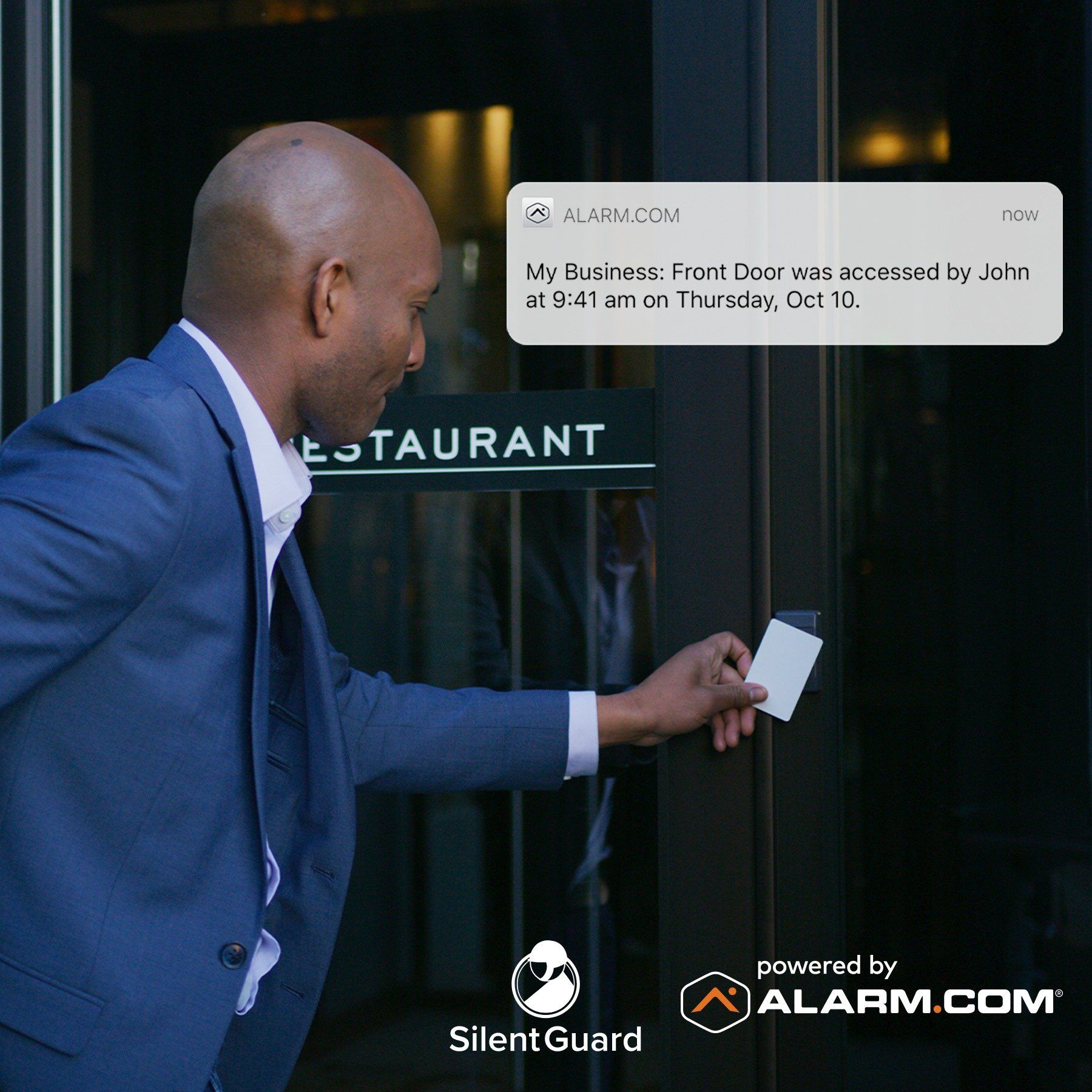 A man in a suit is opening a restaurant door with a card