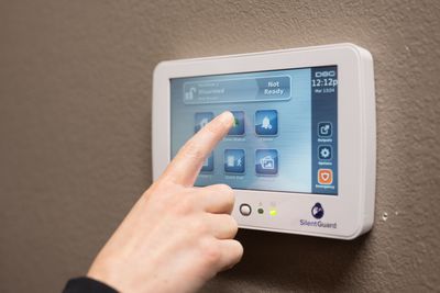 A person is pressing a button on a security system.