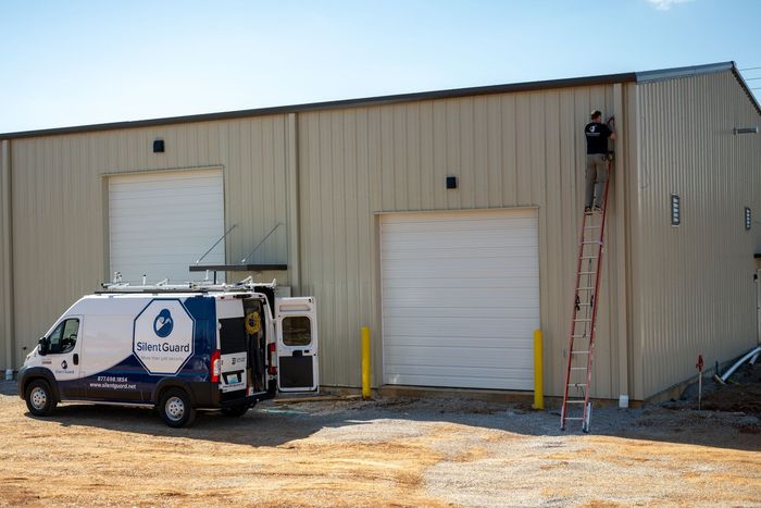 A blue and white van is parked in front of a building.