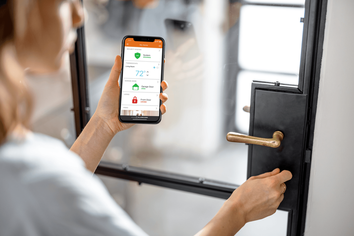 A woman is using a smart phone to open a door.