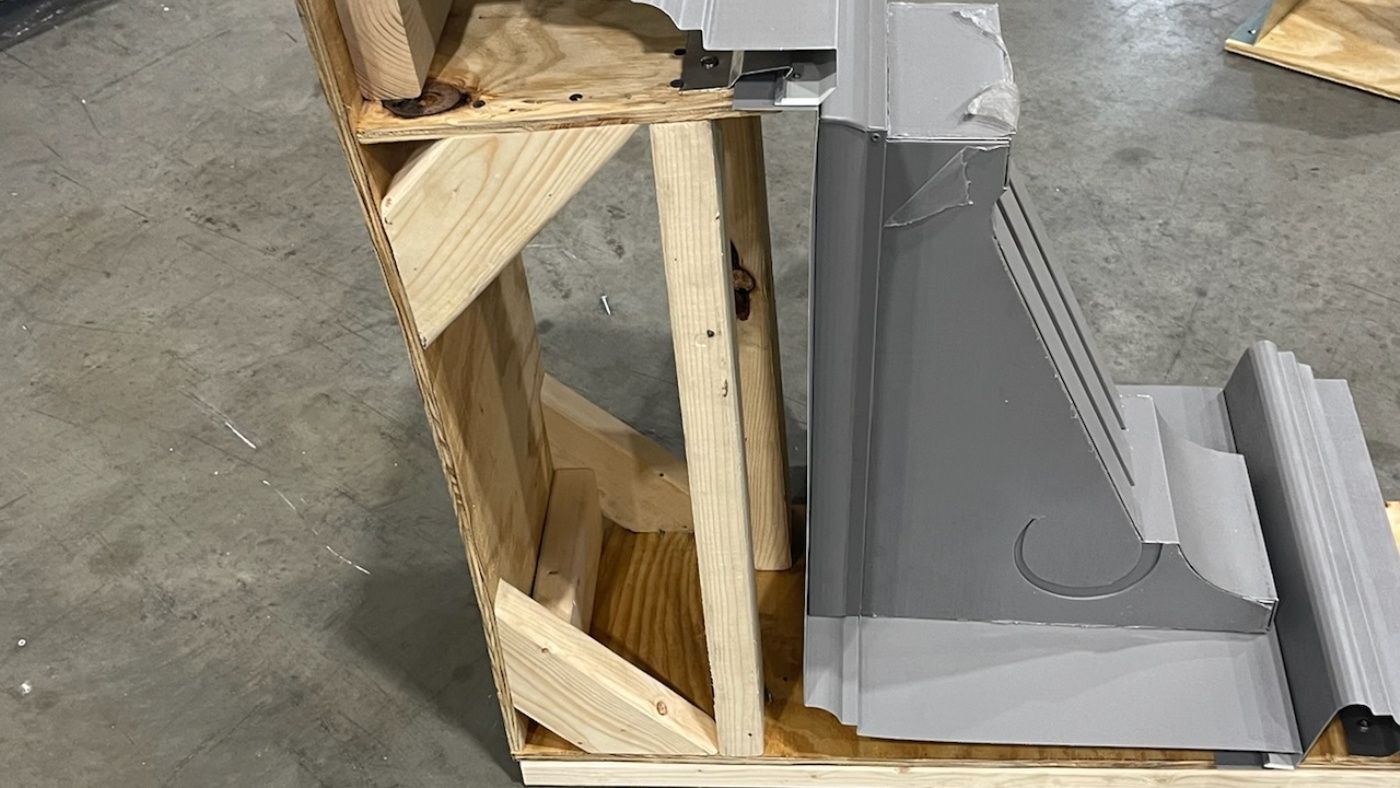 Side view of a formed assembly resting within a visible wooden support.