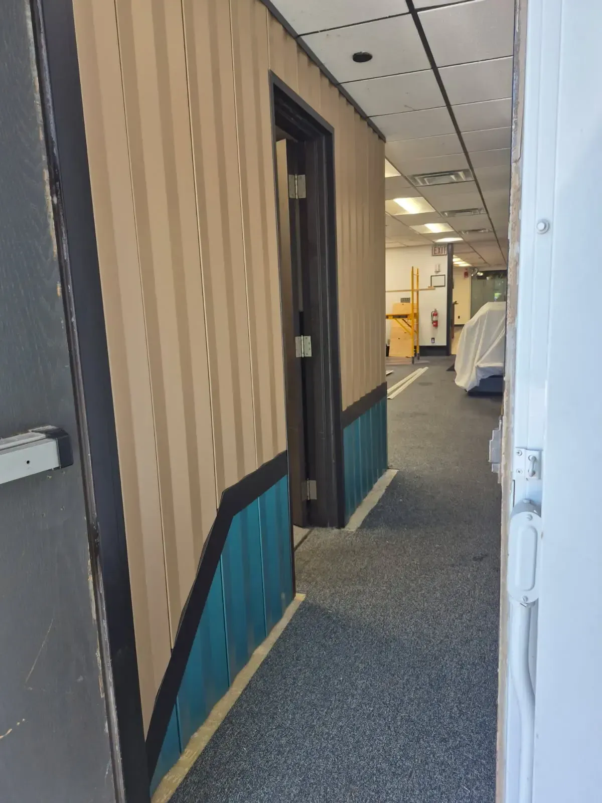 Angled view of a two-tone interior wall-panel layout continuing beside a doorway.