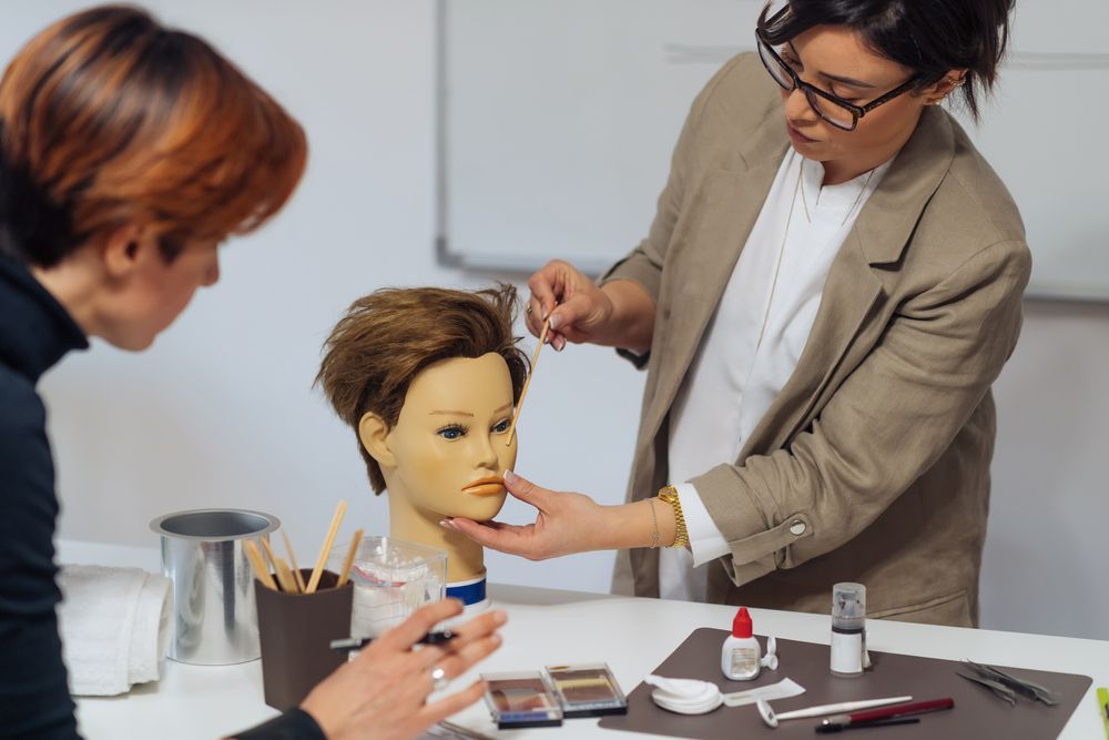A woman is applying makeup to a mannequin head.