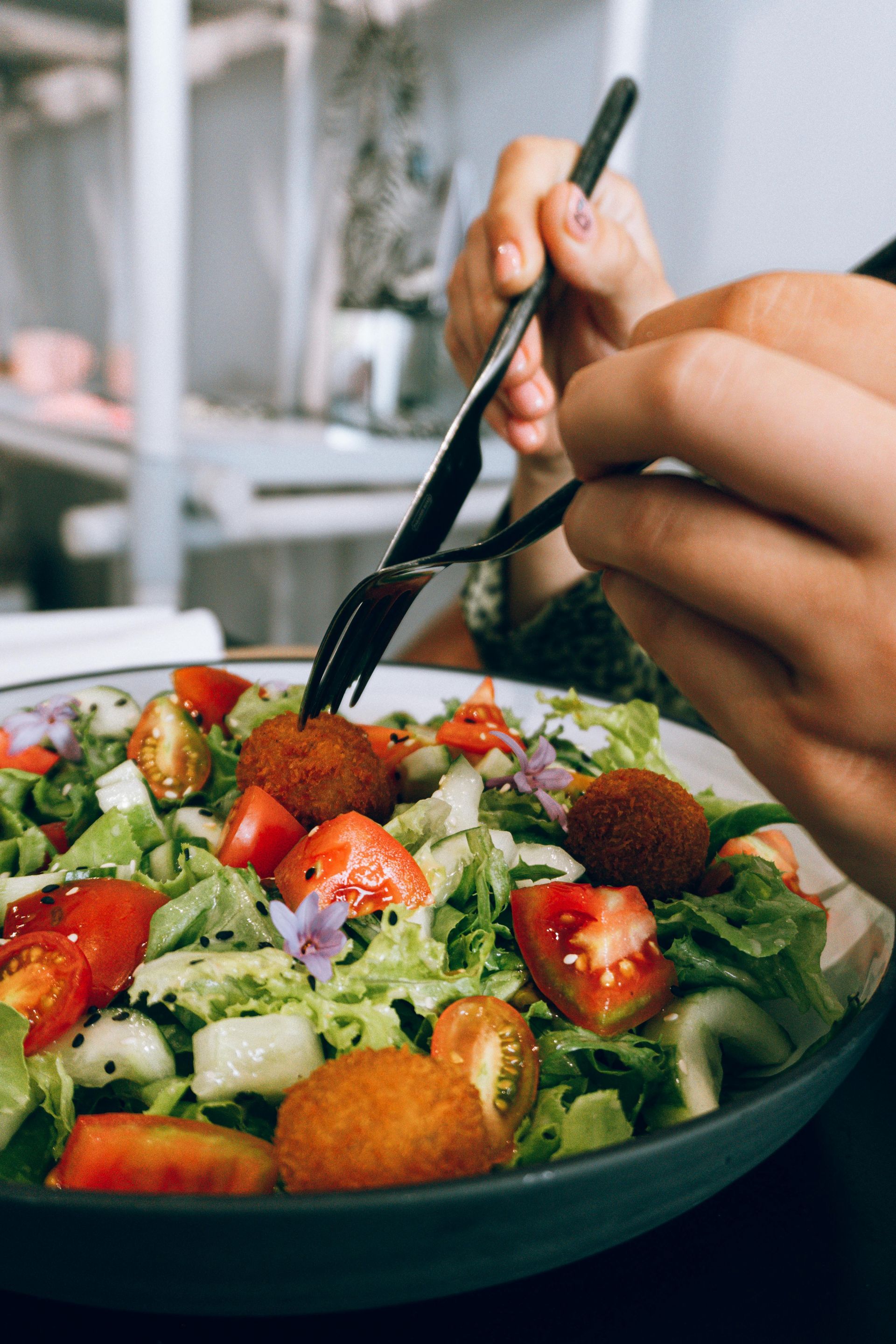 A person is eating a salad with a fork.
