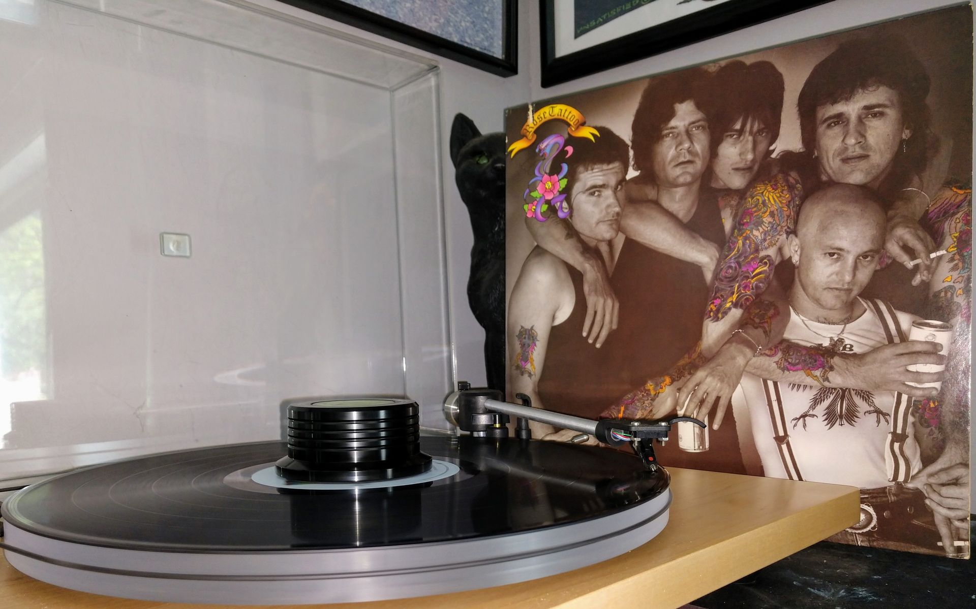 A record player is playing a record in front of a picture of a group of people.
