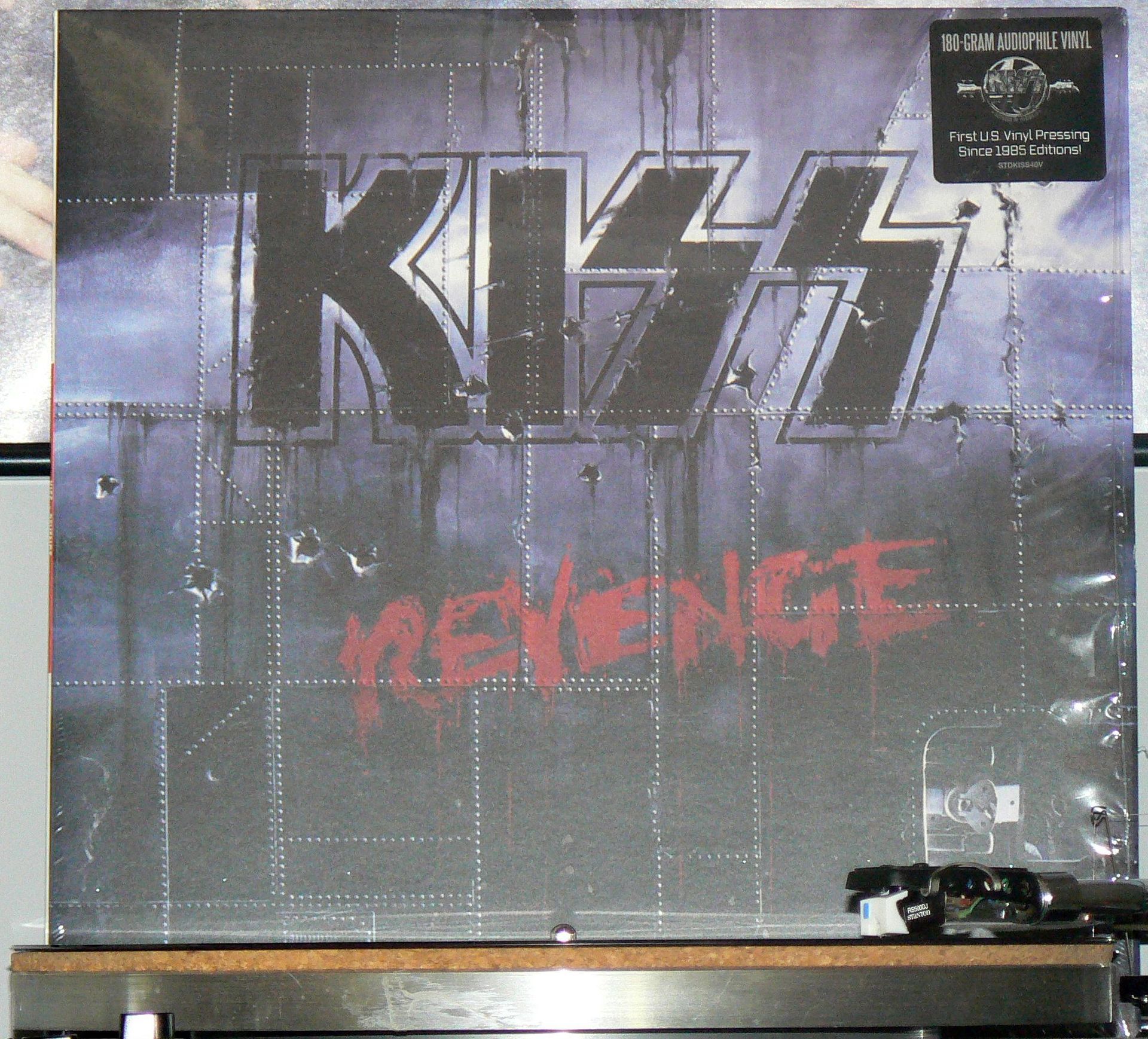 A kiss revenge album is displayed on a shelf