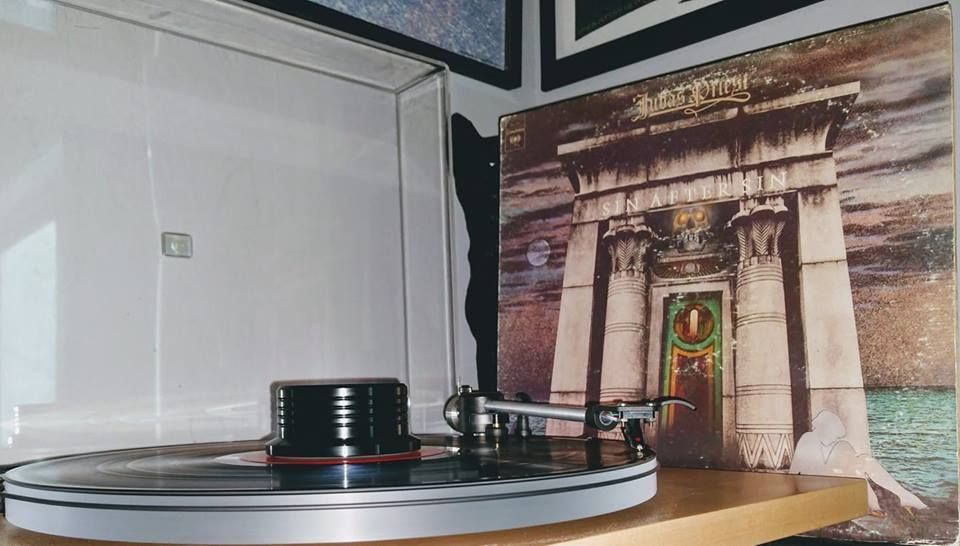 A record player is playing a record in front of a picture of a building.