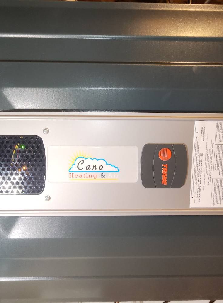 Close-up of a furnace control panel with a green light, a sticker for 