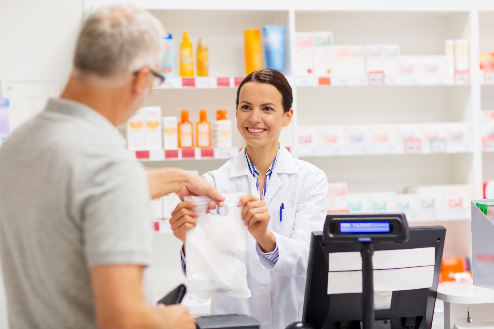 Pharmacist handing a prescription to a customer