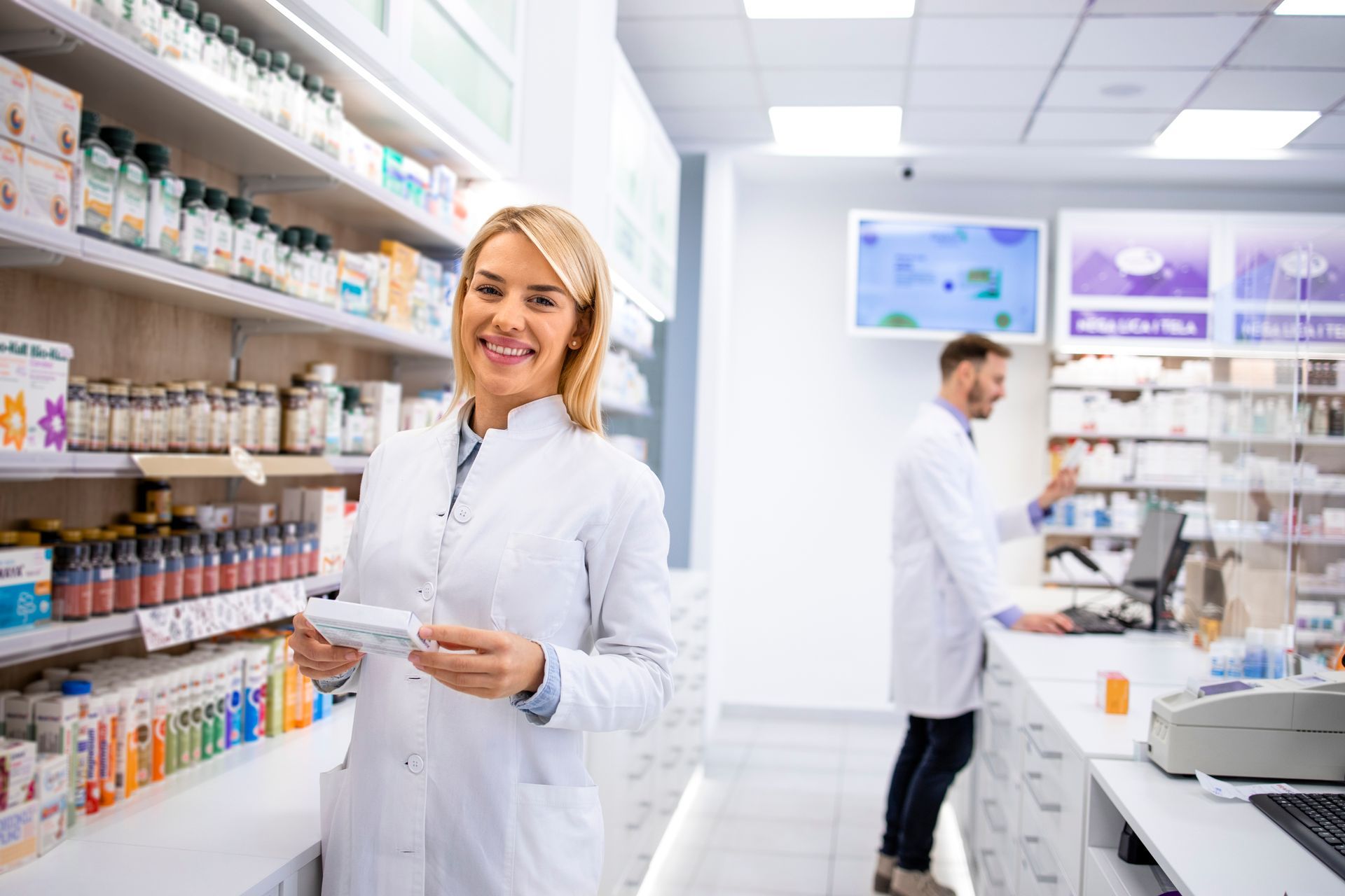 Smiling pharmacist holding medication