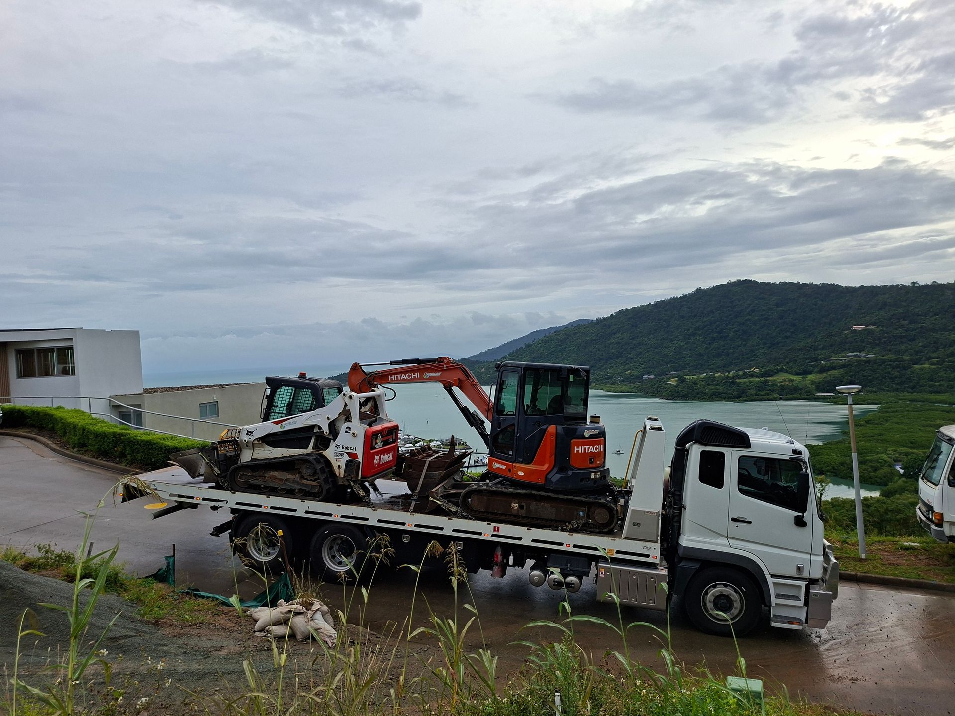 A Tow Truck With a White Van on Top of It — Airlie Towing & Tilt Tray Hire In Cannonvale, QLD