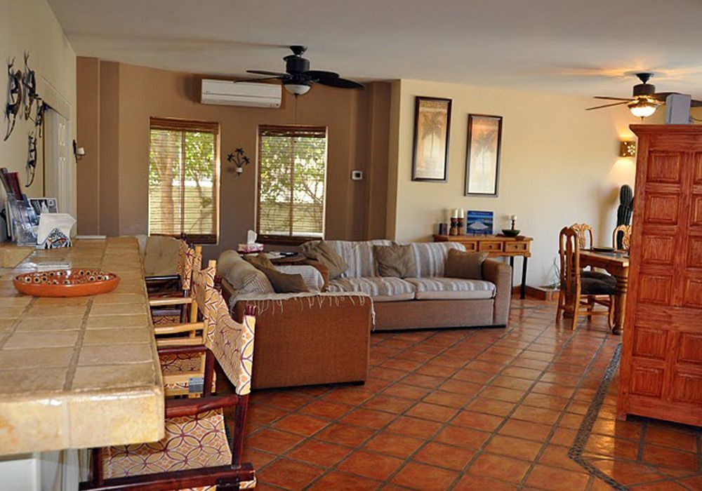 A living room with a couch and chairs and a ceiling fan