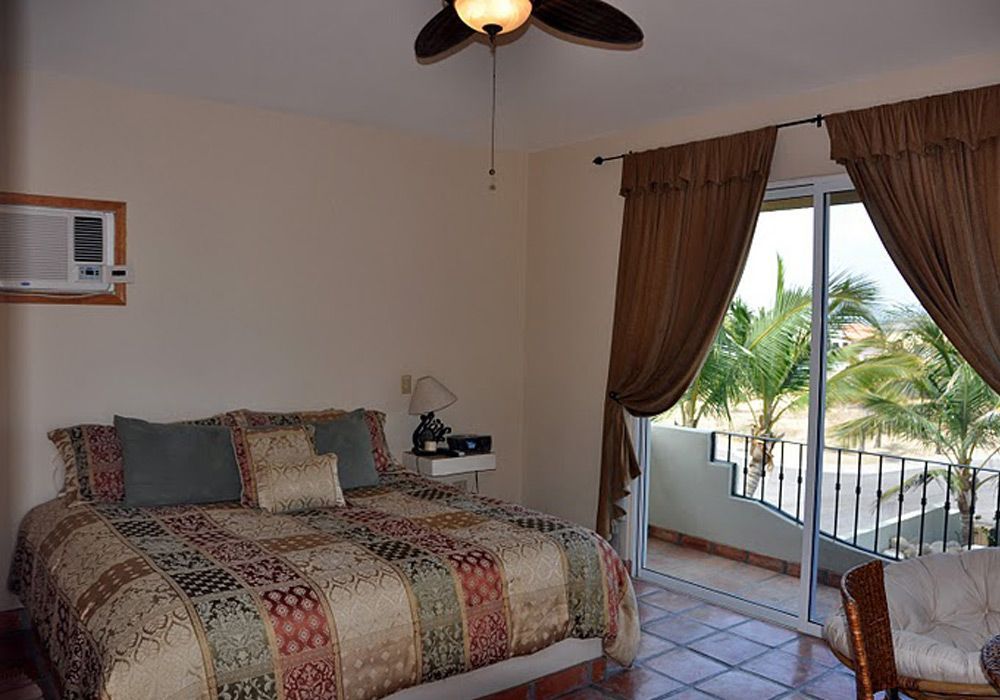 A bedroom with a large bed and a ceiling fan