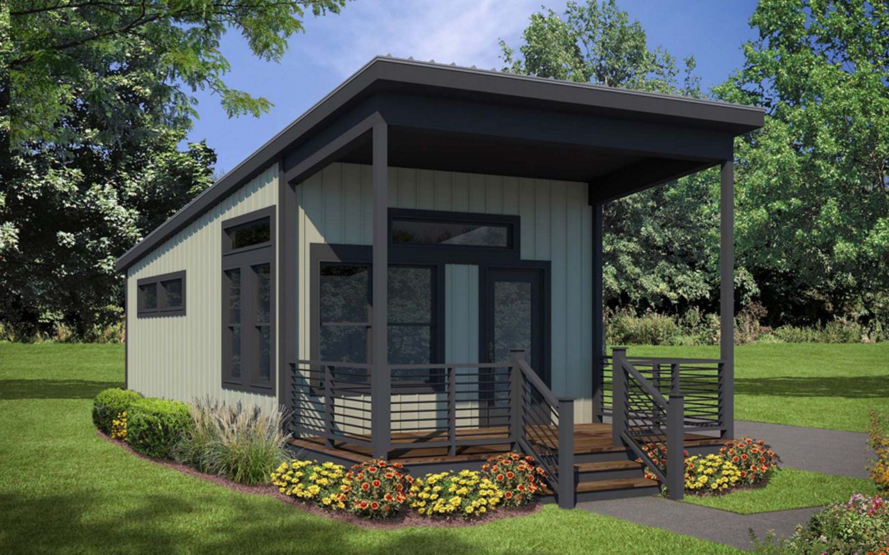 Tiny modern cabin with porch and steps on a grassy lot.