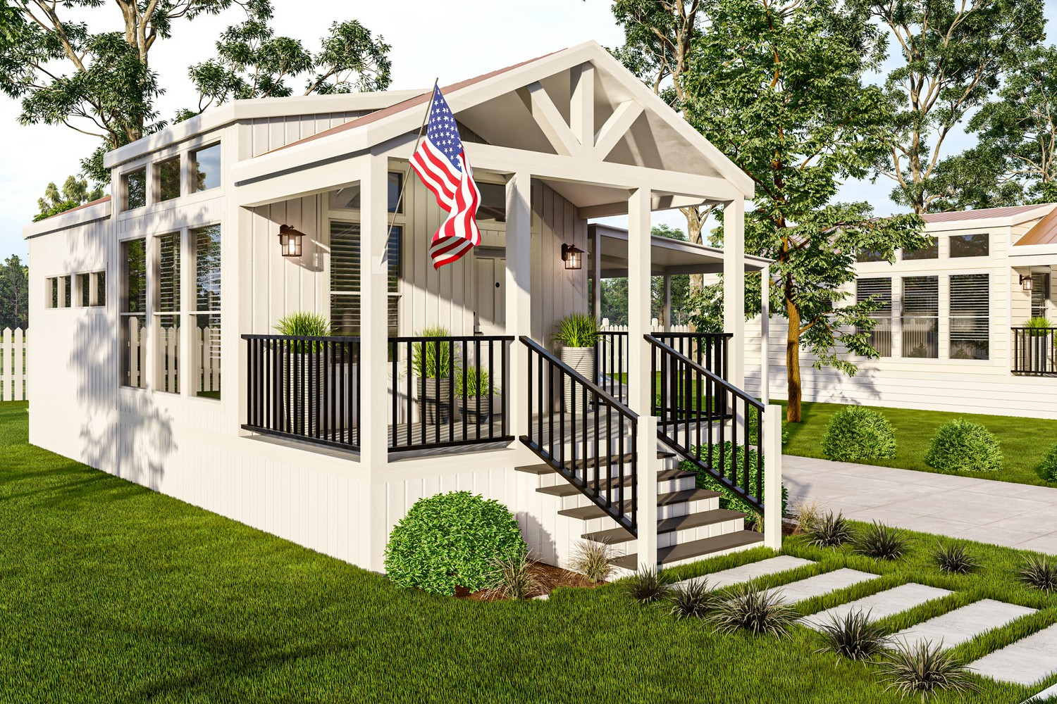 White tiny house with porch and American flag; green lawn and trees.