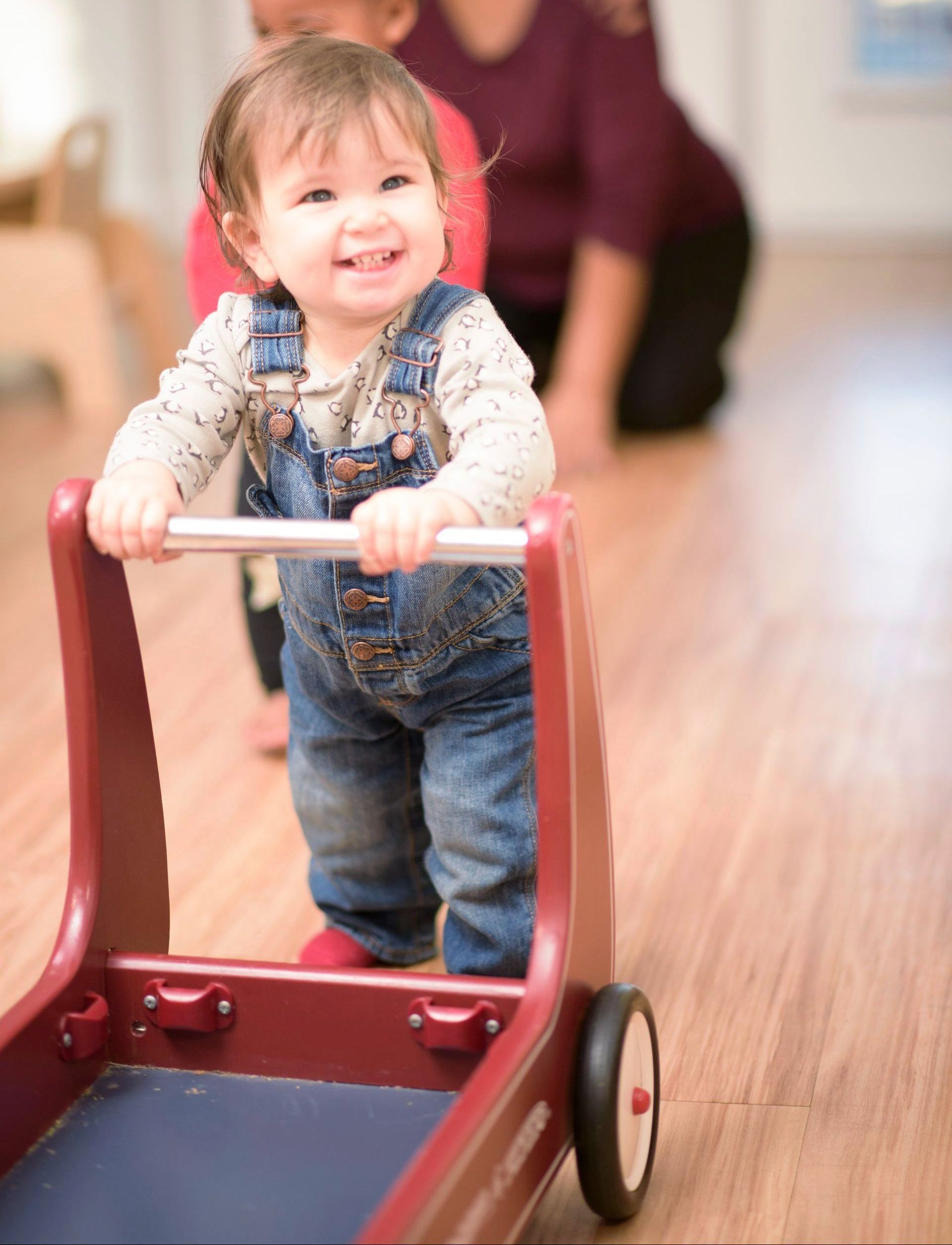 Montessori infant pushing a cart