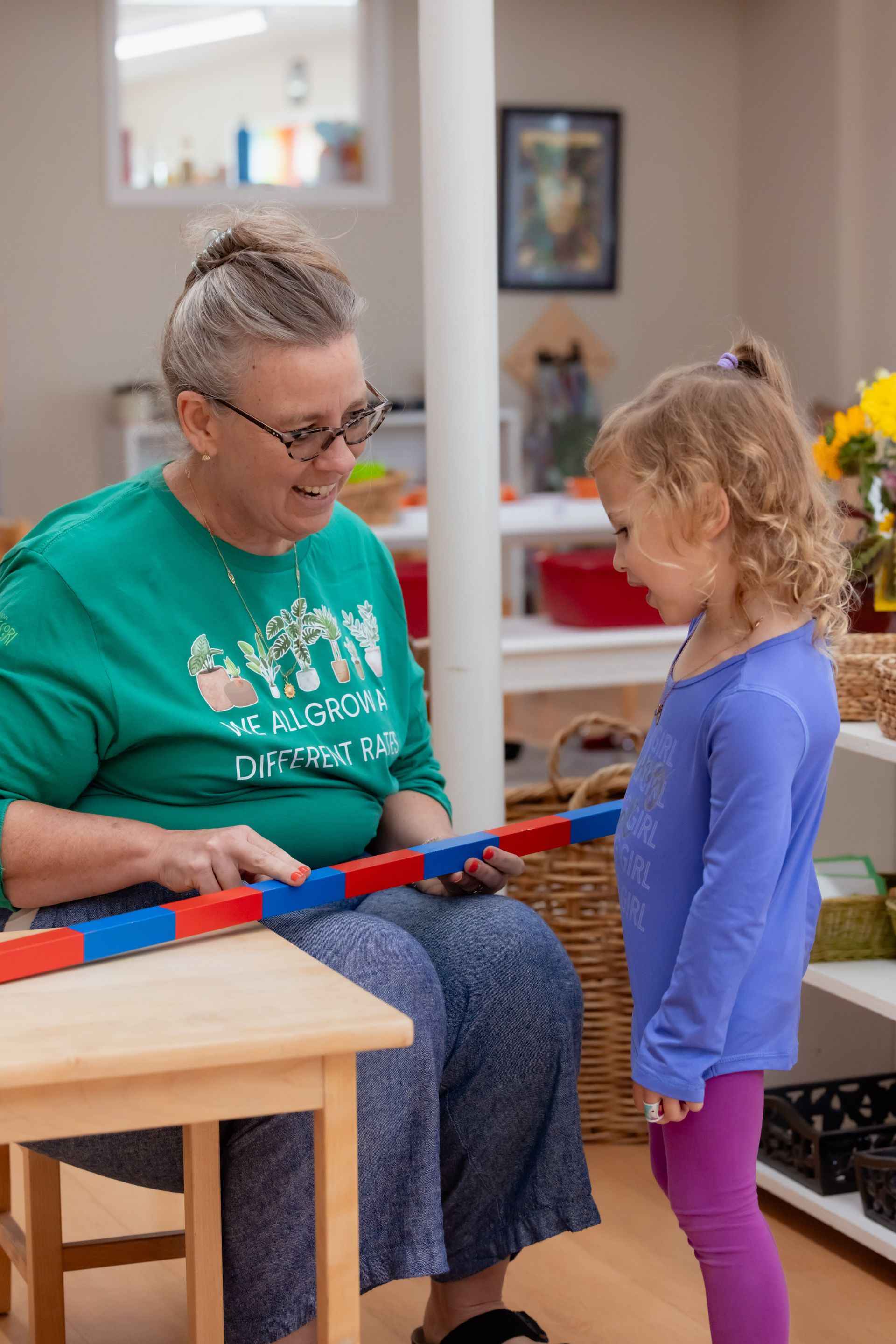 Guide and child working with the Montessori number rods