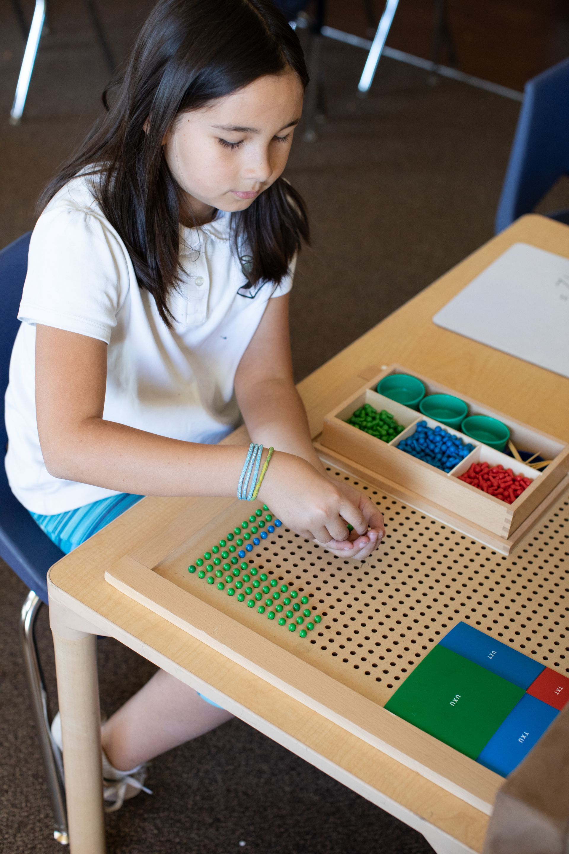 Child working with Montessori pegs board