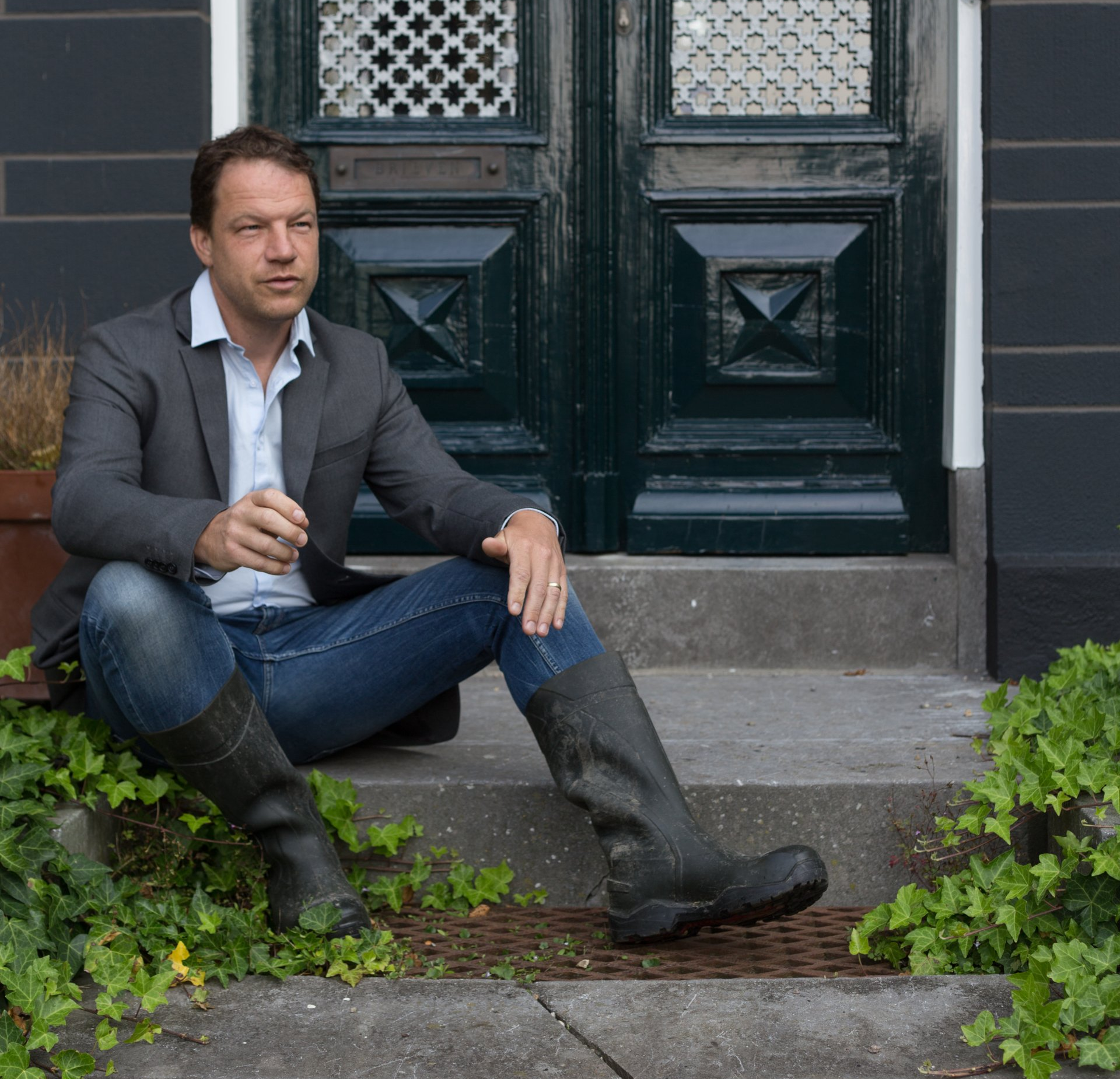 Christian Kolk zit op de trap bij de voordeur van het herenhuis Oosterhouw in Leens Christian Kolk van KTK Tuinontwerp en Groenadvies zit op de trap bij de voordeur van het herenhuis Oosterhouw in Leens