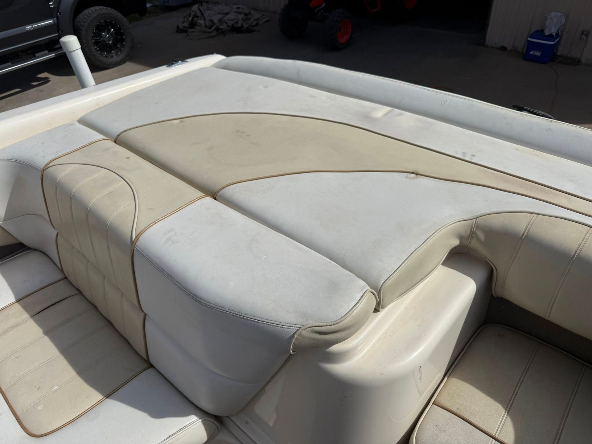 Beige and white upholstered boat lounge seating on a deck, viewed from above.