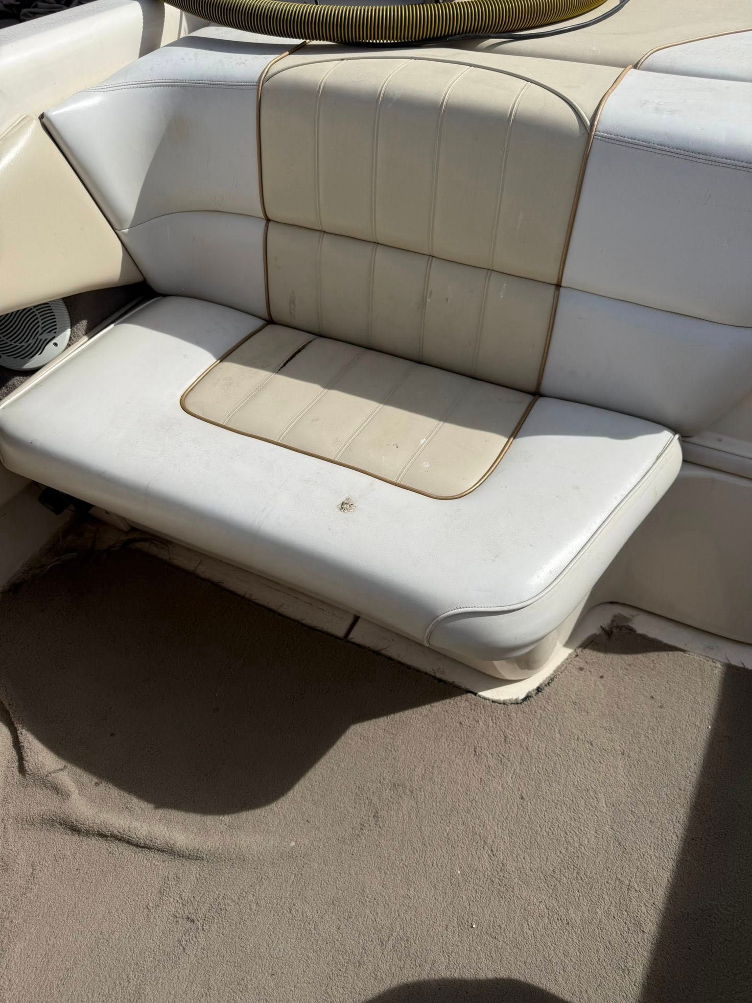 White leather boat bench seat with beige center panels on a sunny deck