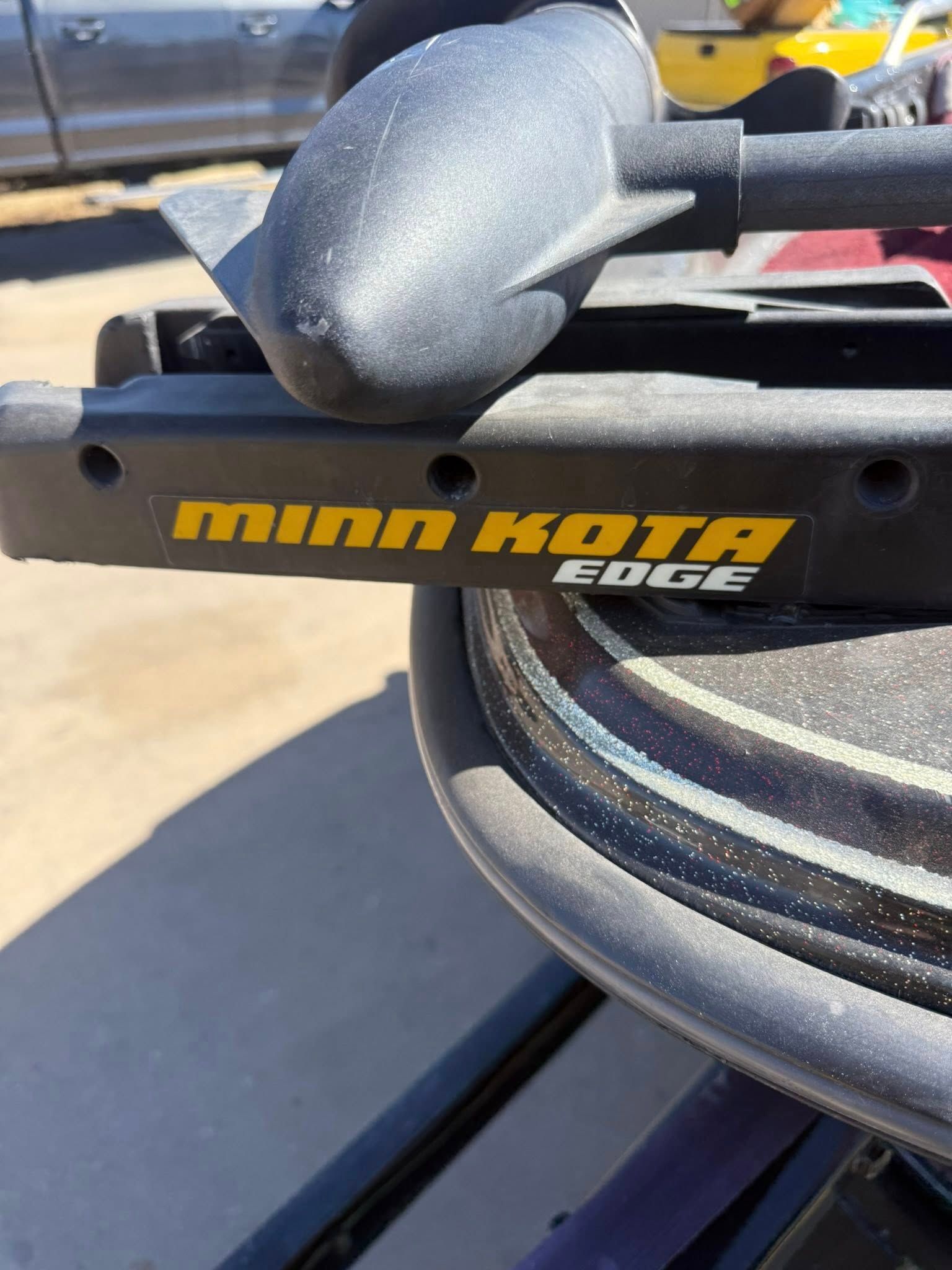 Minn Kota Edge trolling motor mount with black and yellow logo on a boat deck