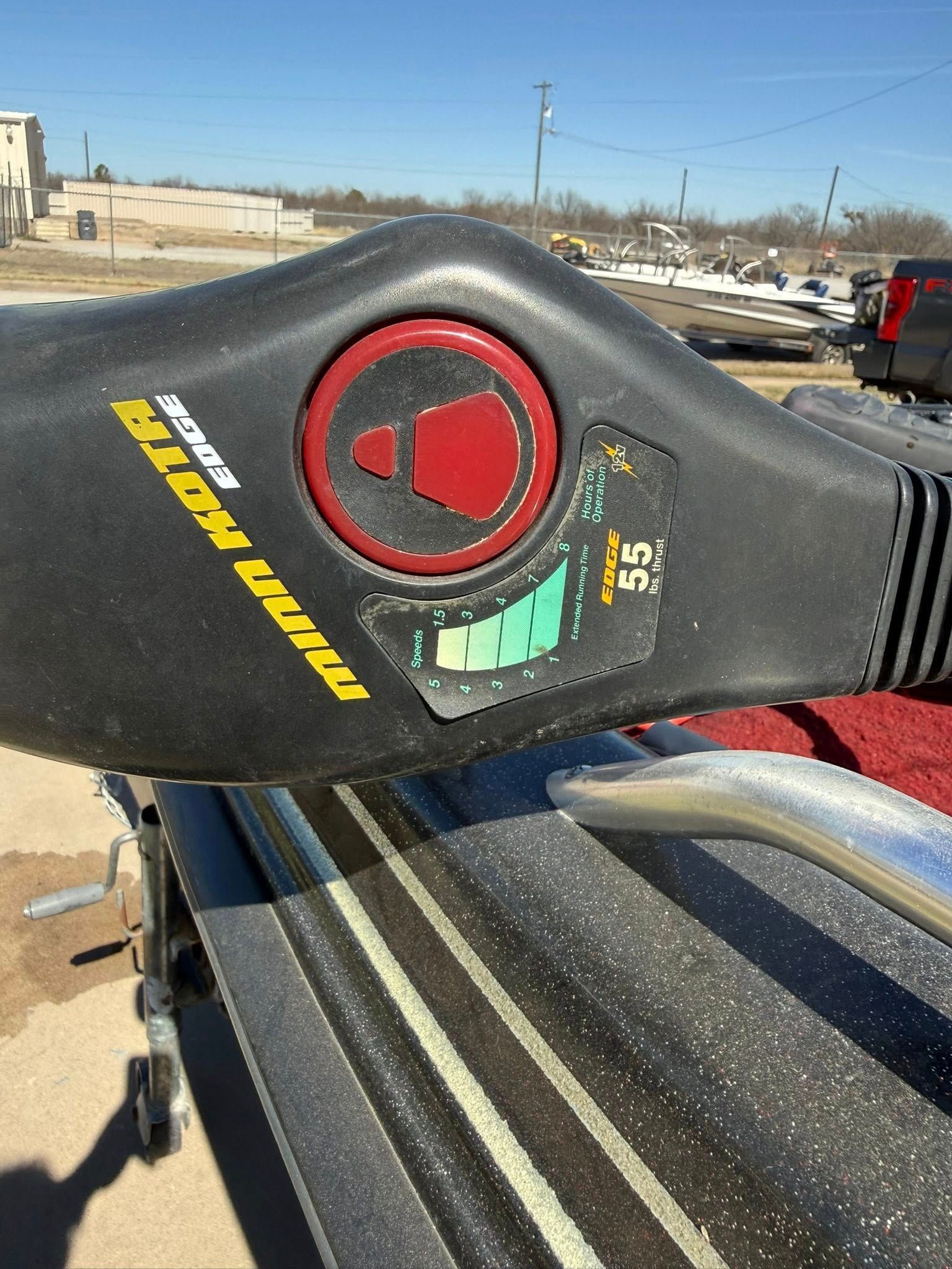 Close-up of a black and red seat belt buckle on a vehicle seat with yellow branding.