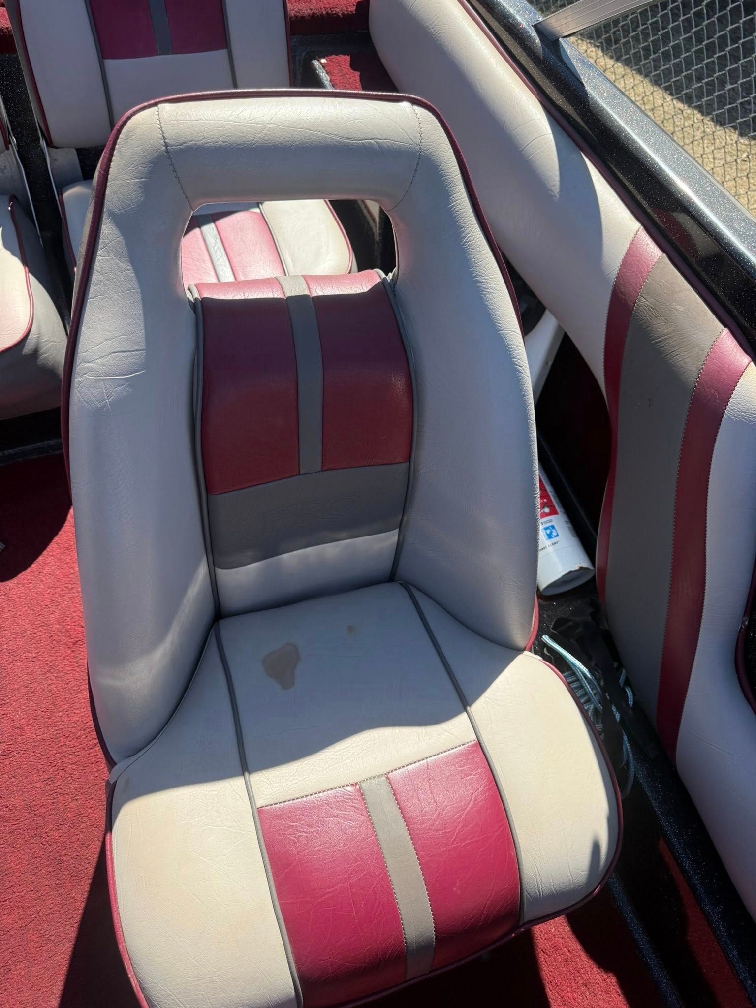 Boat seat with gray upholstery and red center stripes, viewed from above.