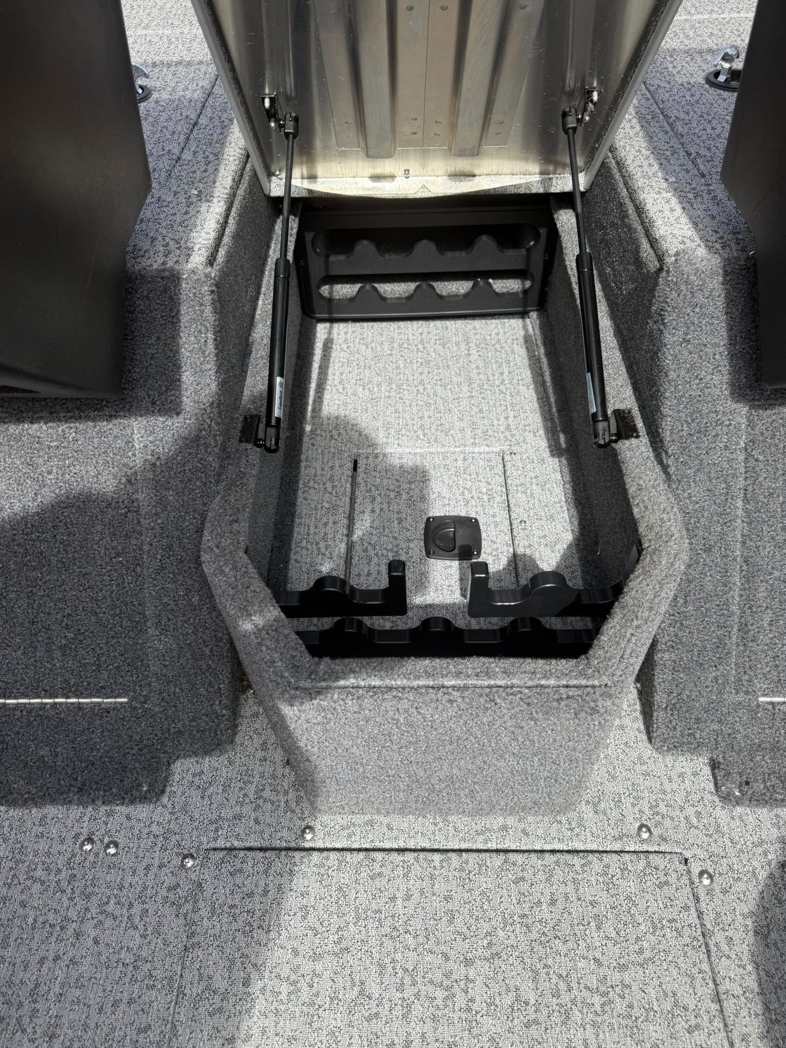 Open roof hatch on a gray textured surface, with a metal latch and recessed compartment.